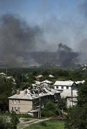 A damaged building can be seen in Lysychansk as black smoke rises from the nearby city of Severodonetsk — BBC News.