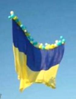 A Ukrainian flag is raised with balloons on Independence Day in Avdiivka in the Donetsk region of Ukraine. — BBC News